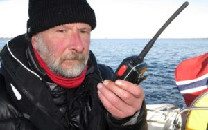 Bildet viser en mann som bruker vhf radio på en båt