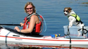 Bildet viser eier og hund i båt