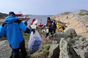 Bildet viser frivillige som rydder kysten.