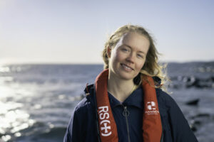 Kvinne ved havet i redningsvest fra Redninsselskapet
